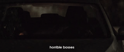 A Man Is Driving A Car At Night With Horrible Bosses Written On The Bottom Of The Screen GIF