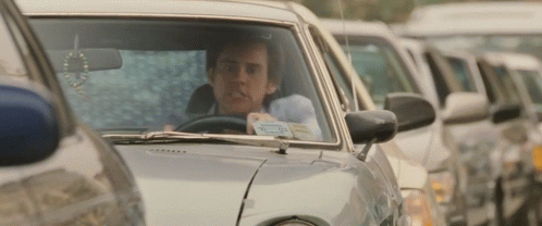 A Man Is Driving A Car With A License Plate That Says ' R.j. ' On It GIF
