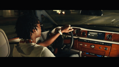 A Man Is Driving A Car With A Radio That Says ' Spotify ' On It GIF