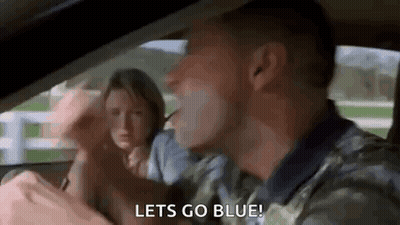 A Man Is Driving A Car With A Woman Behind Him And Says `` Let 'S Go Blue '' . GIF