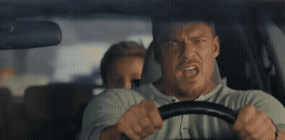 A Man Is Driving A Car With Another Man Behind Him GIF