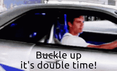 A Man Is Driving A Car With The Words " Buckle Up It 'S Double Time " GIF