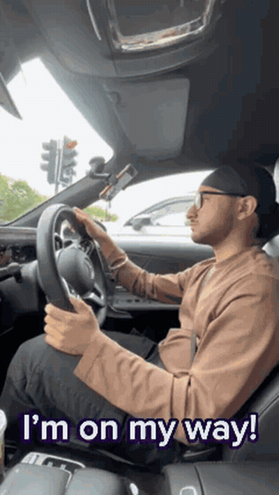 A Man Is Driving A Car With The Words `` I 'M On My Way '' Written Above Him . GIF