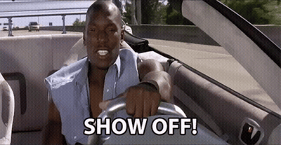 A Man Is Driving A Car With The Words Show Off On The Steering Wheel GIF