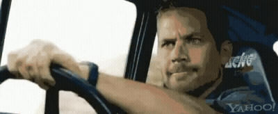 A Man Is Driving A Car With Yahoo Written On The Back Seat GIF