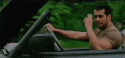 A Man Is Driving A Convertible Car And Making A Funny Face . GIF