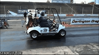 A Man Is Driving A Golf Cart On A Track With A Darlington Drag Sign In The Background GIF