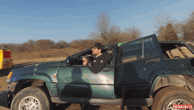 A Man Is Driving A Green Jeep With The Word Thinkiules On The Bottom Right GIF