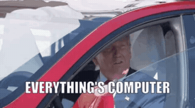 A Man Is Driving A Red Car With The Words " Everything 'S Computer " On The Bottom GIF