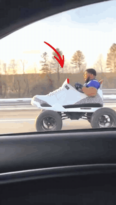 A Man Is Driving A Toy Car That Looks Like A Shoe With A Red Arrow Pointing To It GIF