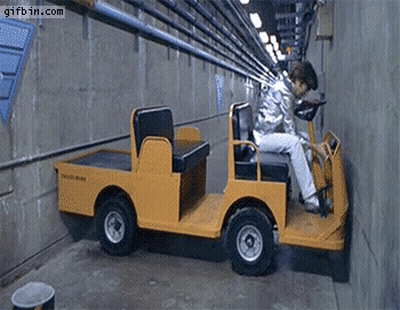 A Man Is Driving A Yellow Vehicle That Says South State On It GIF