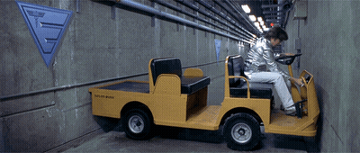 A Man Is Driving A Yellow Vehicle That Says Taylor Built GIF