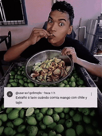 A Man Is Eating A Bowl Of Food Next To A Sign That Says A GIF