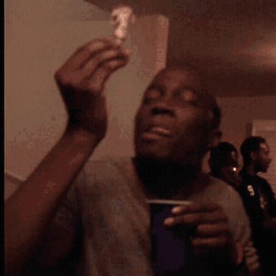 A Man Is Eating A Piece Of Cake With A Smile On His Face GIF