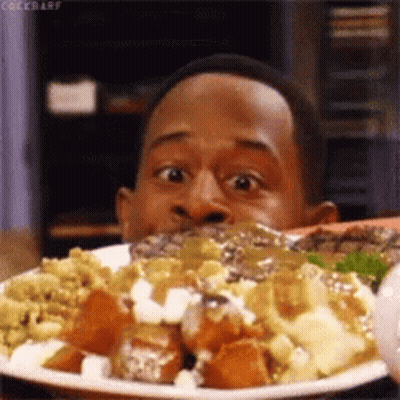 A Man Is Eating A Plate Of Food And Making A Funny Face . GIF