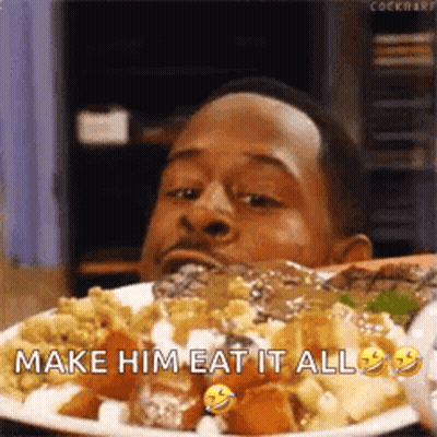 A Man Is Eating A Plate Of Food With The Caption `` Make Him Eat It All '' . GIF
