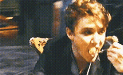 A Man Is Eating A Sandwich With A Fork And Spoon . GIF