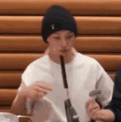 A Man Is Eating A Sausage With A Knife And Fork . GIF