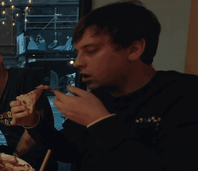 A Man Is Eating A Slice Of Pizza While Wearing A Shirt That Says " Super Radio " GIF