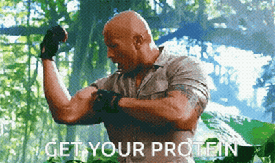 A Man Is Flexing His Muscles With The Words Get Your Protein Written Below Him GIF