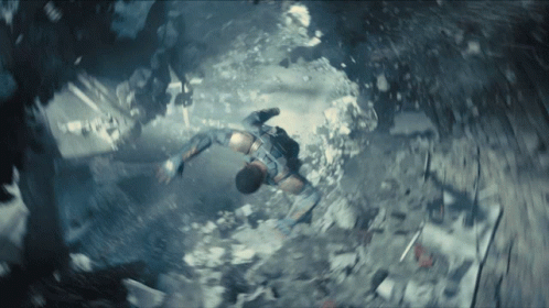 A Man Is Flying Through The Air In A Very Dark Room GIF