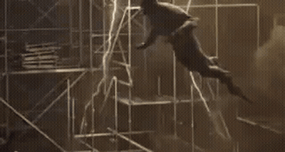 A Man Is Flying Through The Air While Holding A Light . GIF