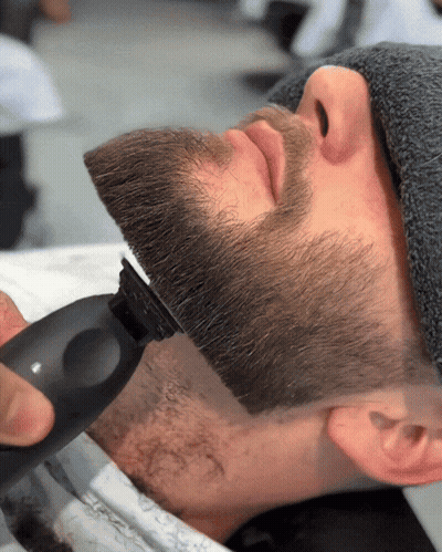 A Man Is Getting His Beard Shaved With A Machine GIF