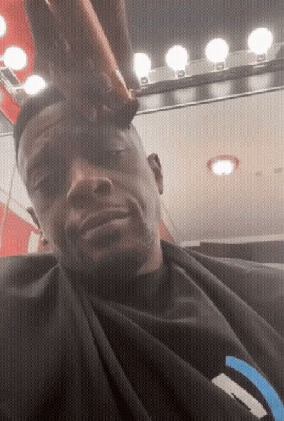 A Man Is Getting His Hair Cut By A Barber GIF