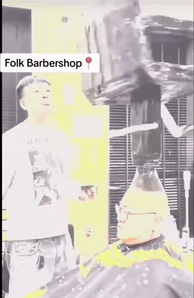 A Man Is Getting His Hair Cut By A Barber In A Folk Barbershop GIF