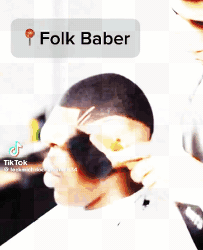A Man Is Getting His Hair Cut By A Barber Using A Folk Baber . GIF