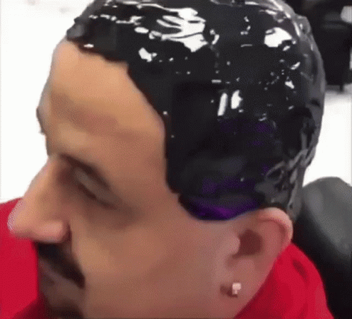 A Man Is Getting His Hair Dyed In A Salon . GIF