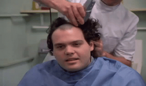 A Man Is Getting His Head Shaved By A Hairdresser . GIF
