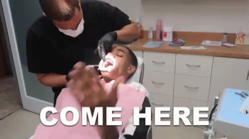 A Man Is Getting His Teeth Examined By A Dentist And The Words Come Here Are Visible GIF
