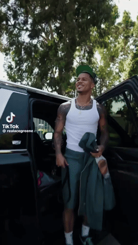 A Man Is Getting Out Of A Car With A Tik Tok Sticker On The Back GIF