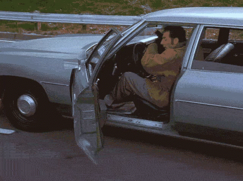 A Man Is Getting Out Of A Car With His Door Open GIF