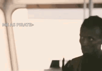 A Man Is Giving A Peace Sign While Standing In Front Of A Window And Says `` Me As Pirate '' . GIF