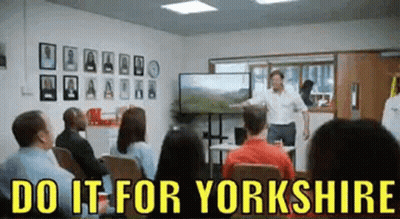 A Man Is Giving A Presentation In Front Of A Group Of People In A Room . GIF