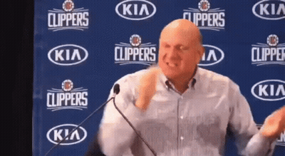 A Man Is Giving A Speech In Front Of A Kia Clippers Banner GIF