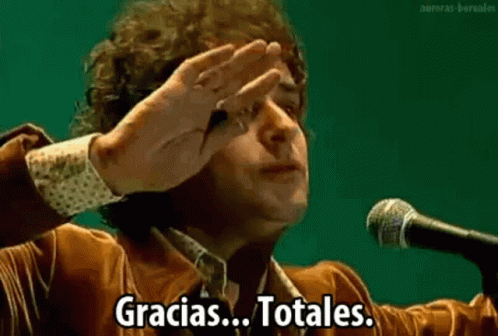 A Man Is Giving A Speech In Front Of A Microphone And Covering His Face . GIF