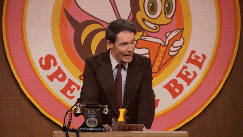 A Man Is Giving A Speech In Front Of A Sign That Says Spe Bee GIF