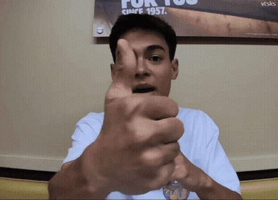 A Man Is Giving A Thumbs Up In Front Of A Poster That Says For You Since 1957 GIF