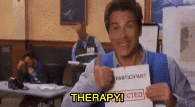 A Man Is Giving A Thumbs Up While Holding A Piece Of Paper That Says Therapy . GIF
