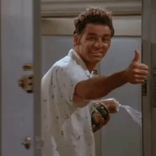 A Man Is Giving A Thumbs Up While Holding A Spray Bottle In His Hand . GIF