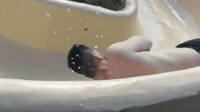 A Man Is Going Down A Water Slide At A Water Park . GIF