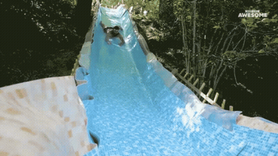 A Man Is Going Down A Water Slide That Says Waterslide Awesome GIF