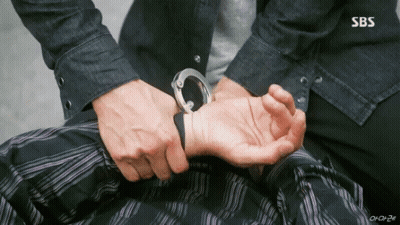 A Man Is Handcuffed To Another Man 'S Wrist In A Sbs Show . GIF