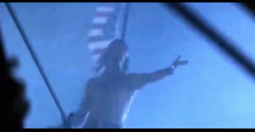 A Man Is Hanging From A Rope In The Air . GIF