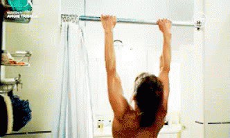 A Man Is Hanging From A Shower Curtain In A Bathroom . GIF