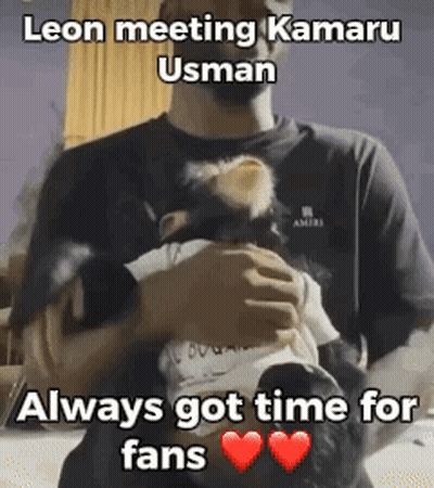 A Man Is Holding A Baby In His Arms With A Caption That Says Leon Meeting Kamaru Usman Always Got Time For Fans GIF