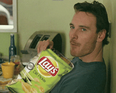 A Man Is Holding A Bag Of Lays Chips GIF